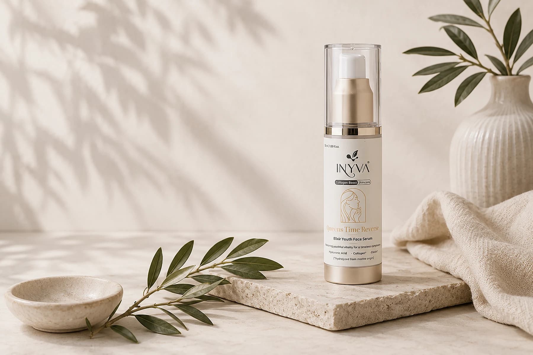INYVA Queen’s Time Reverse Elixir Youth Face Serum on a travertine slab, with an olive sprig, a ceramic dish and a linen cloth